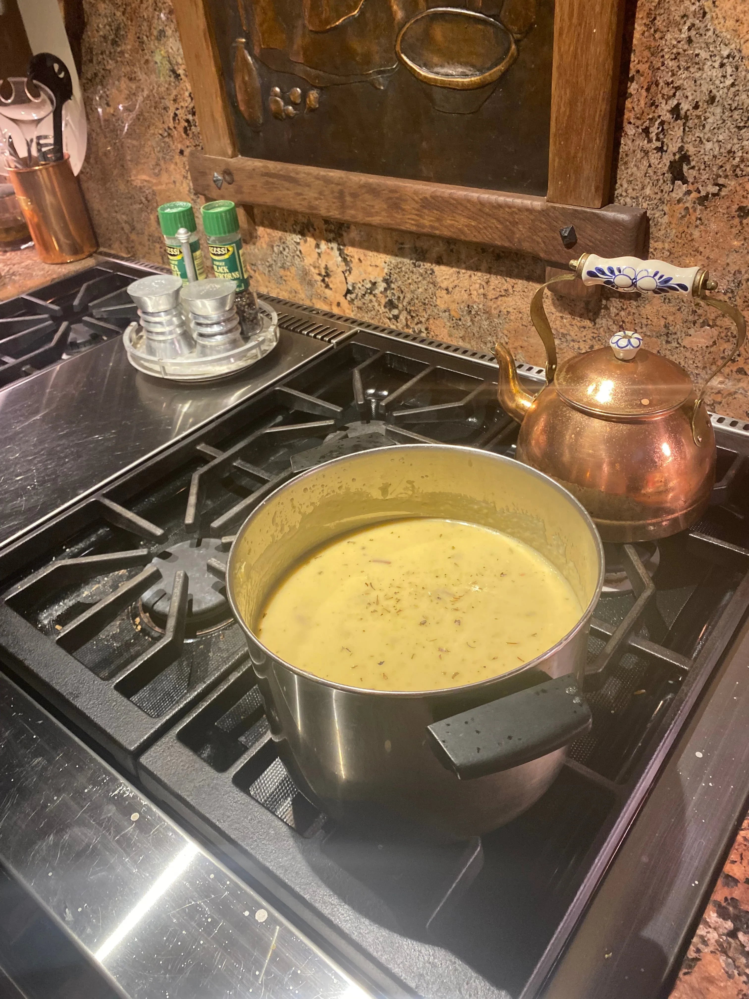Herb-infused soup simmering in stainless steel pot on rustic kitchen stovetop