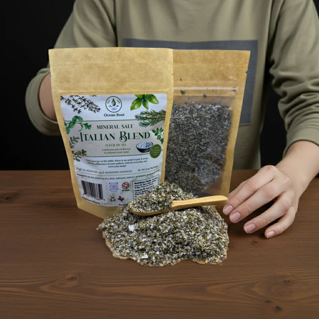 Fleur de Sel Italian Blend mineral salt in kraft pouch, hand scooping herbal salt mix on table