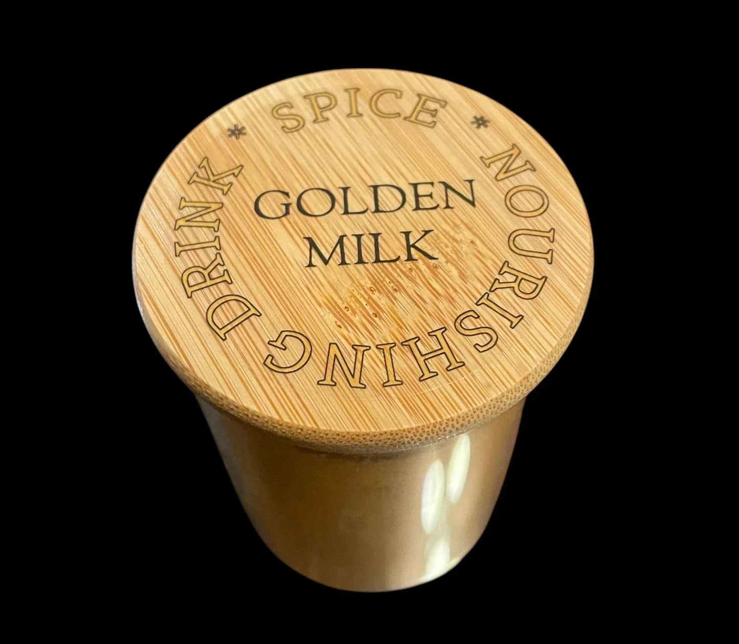 Golden milk powder in a glass jar with bamboo lid, labeled spice nourishing drink.
