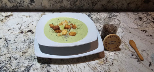 Creamy asparagus soup with croutons, smokey chipotle seasoning on marble countertop