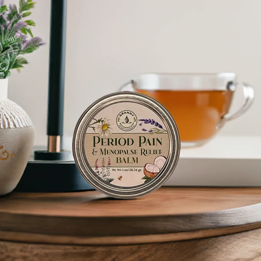 Period Pain and Menopause Relief Balm tin on wooden tray with tea and plant in background